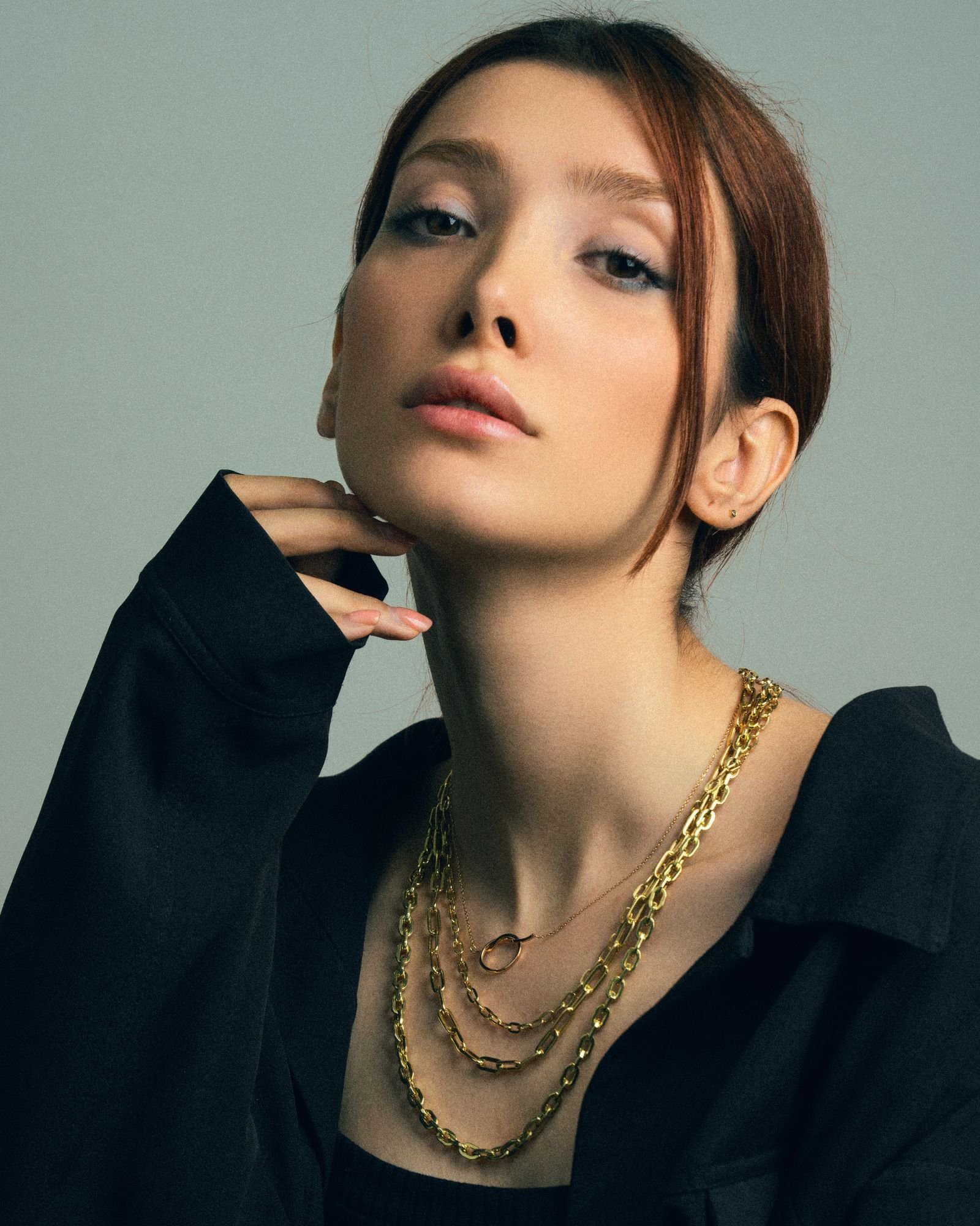 A model wearing layered Lumière gold necklaces